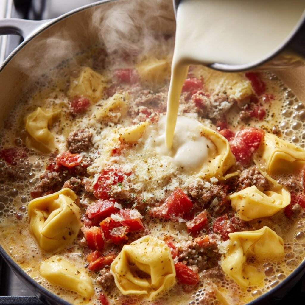 Adding cream and cheese tortellini to italian sausage tortellini soup in a pot.
