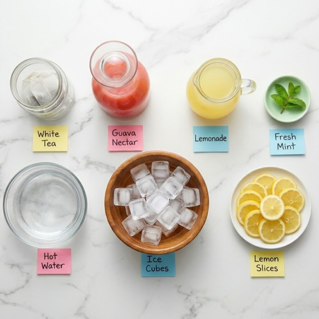 Top down flat lay of tea bags, guava nectar, lemonade, and lemon slices in glass containers on a marble counter.