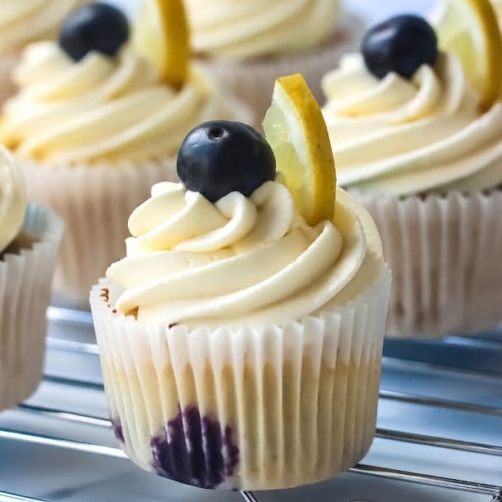 A close-up of Blueberry Lemonade Cupcakes with natural lighting in a simple kitchen.