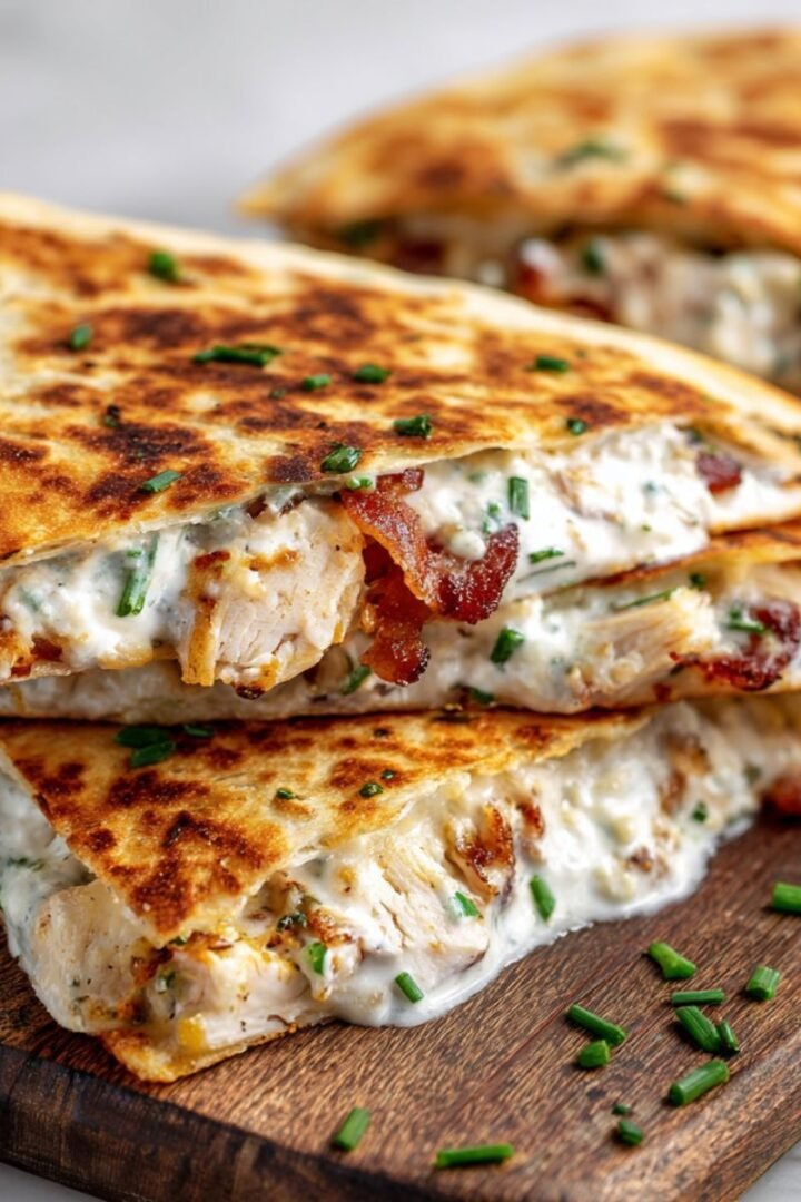 Two chicken bacon ranch quesadilla wedges showing crispy bacon and chicken filling with minimal melted cheese.
