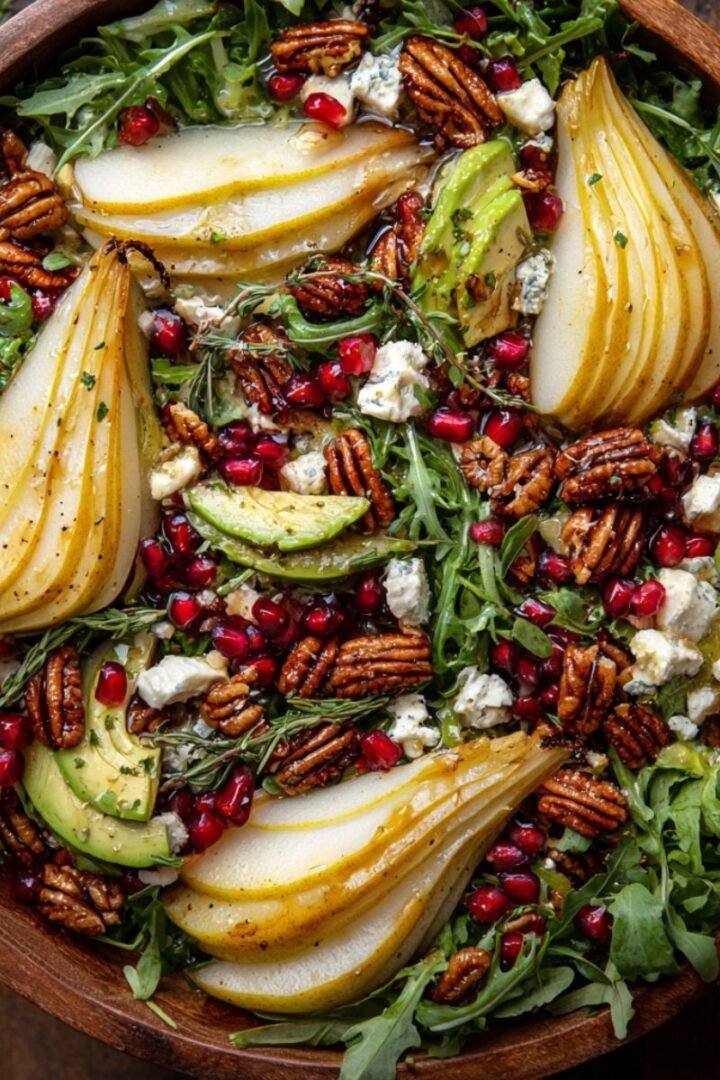Festive 15 minute christmas salad with arugula pears pomegranate candied pecans goat cheese and avocado