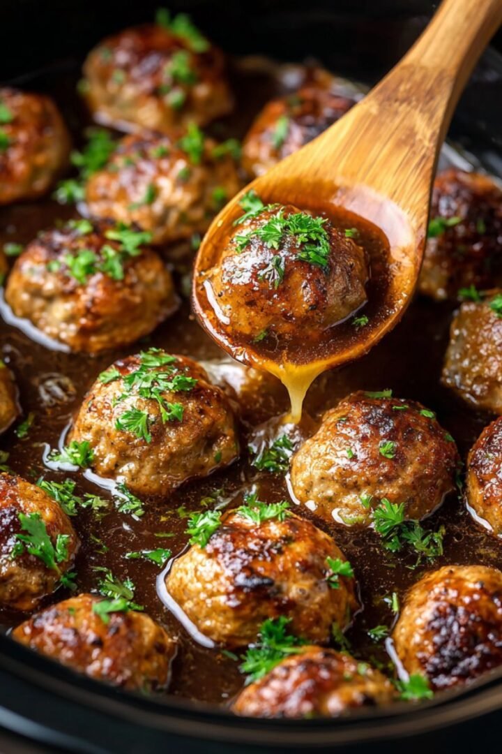 Savory 4 hour crock pot french onion meatballs with melted cheese rich gravy and fresh parsley