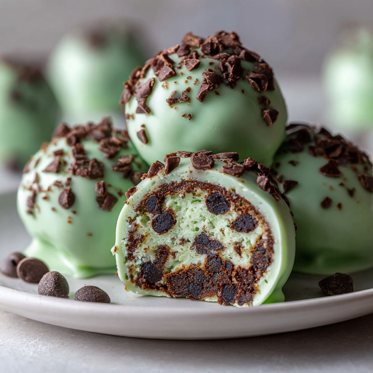 Healthy 15 minute mint chocolate chip protein balls with green coating and chocolate chips showing cross section