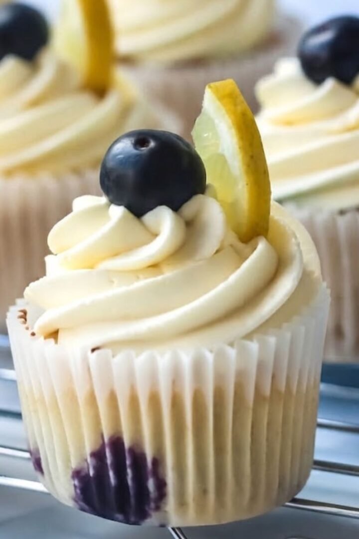 A close-up of Blueberry Lemonade Cupcakes with natural lighting in a simple kitchen.